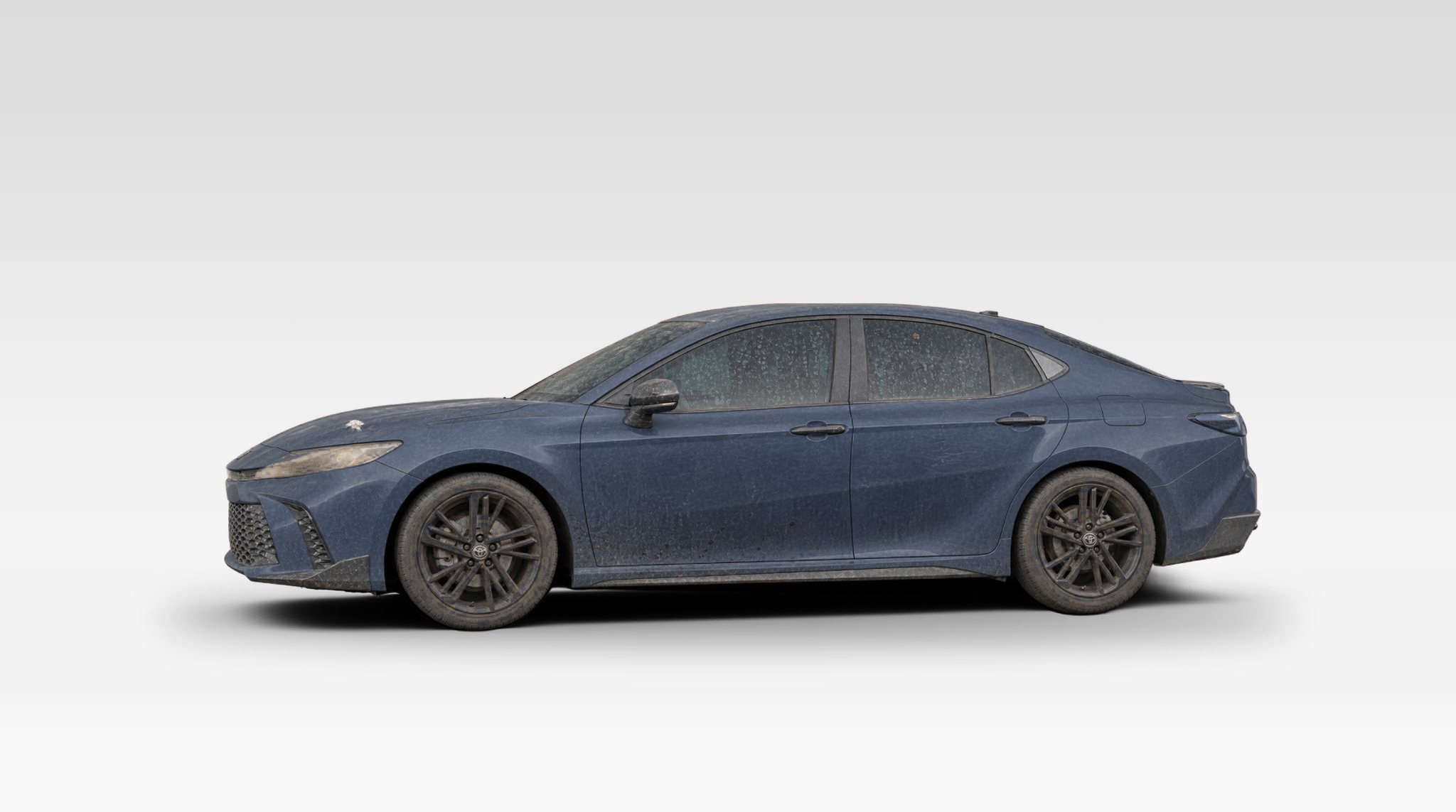 A muddy Cosmos Blue Toyota Camry.