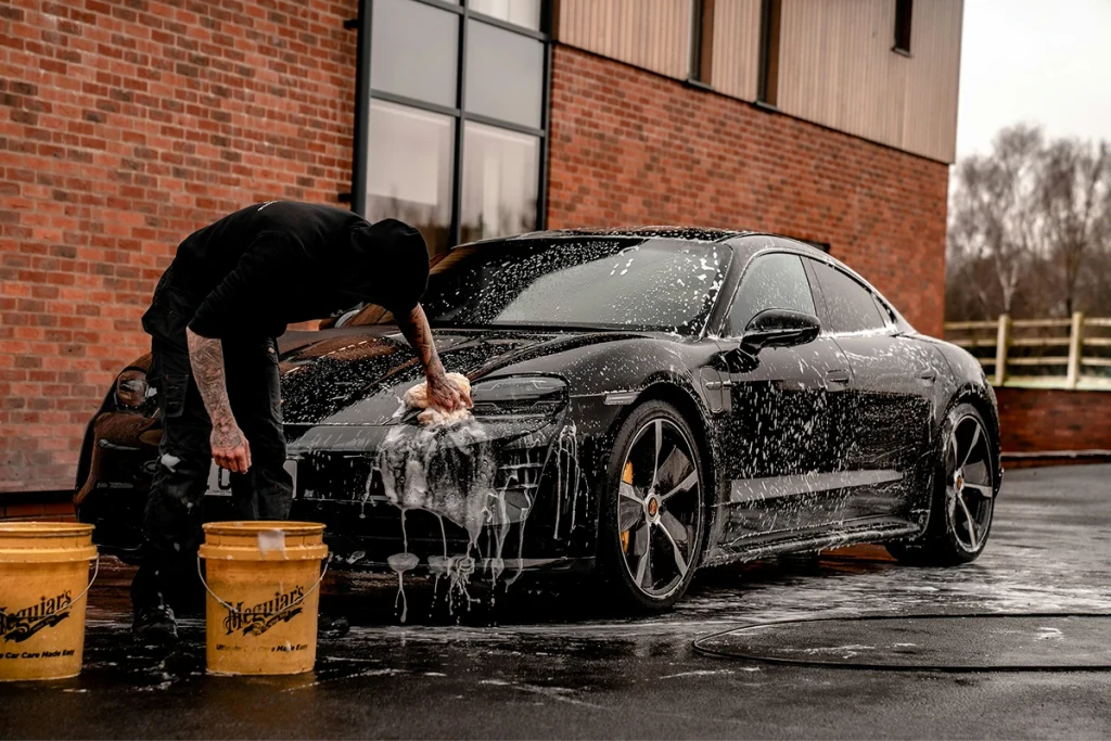A car being hand washed with snow foam